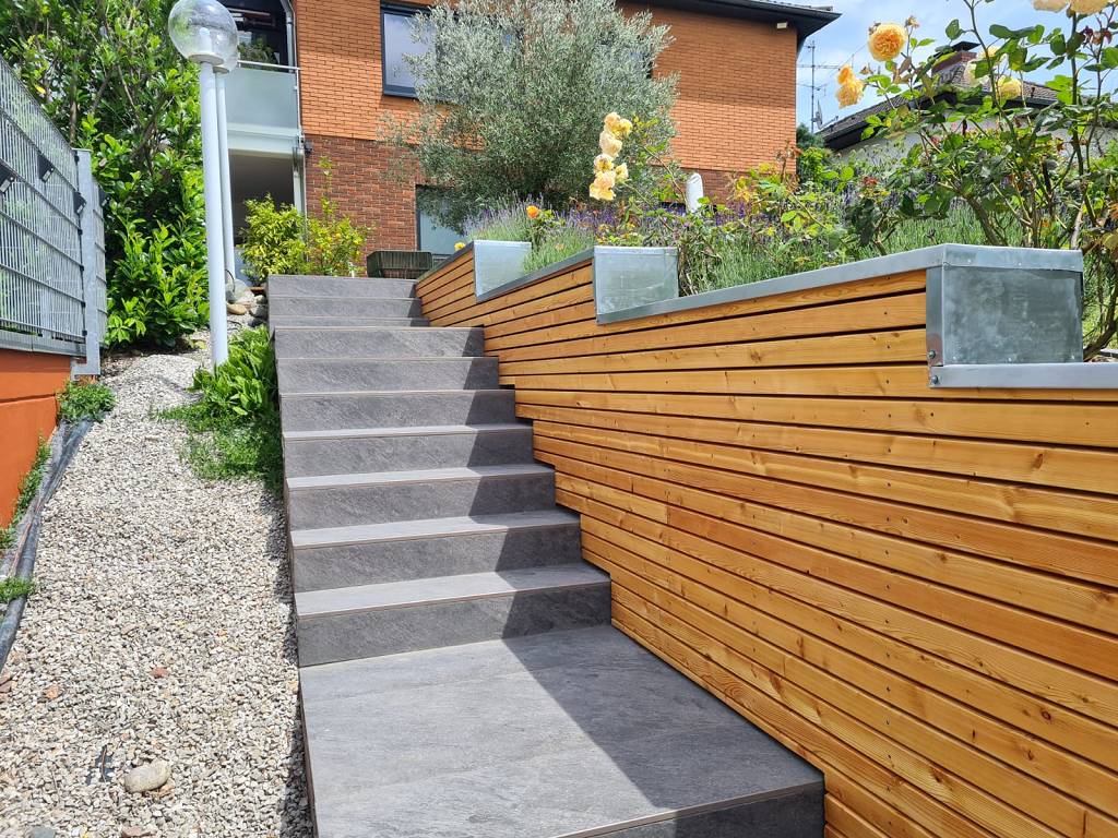 Treppenaufgang mit seitlicher Holzverkleidung und Zinkblechabdeckung.